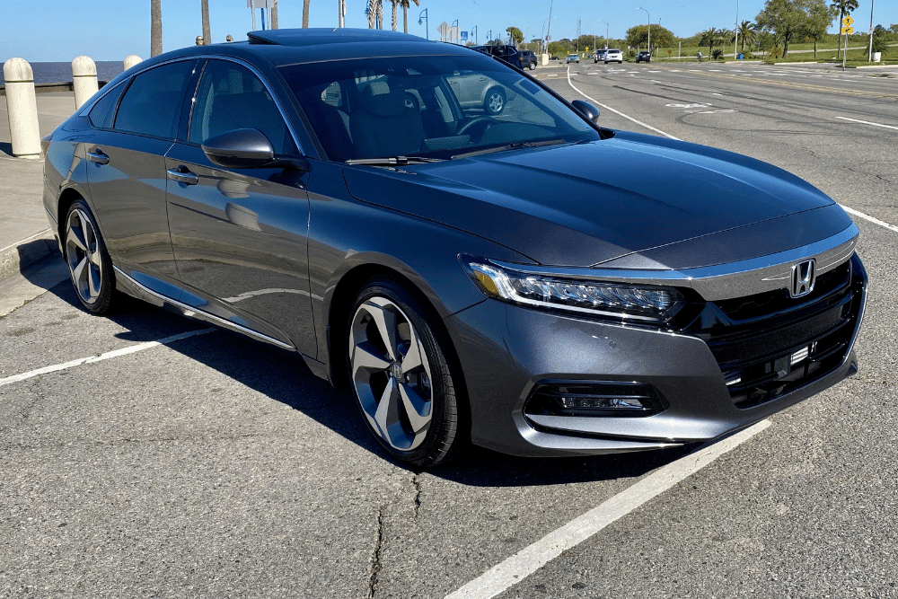 honda repair, auto repair in Killeen, TX at First Choice Automotive Repair. Metallic gray Honda sedan parked in an outdoor lot near a coastal roadway, reflecting sunlight on its sleek body.