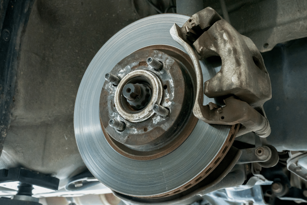 Brake Repair in Killeen, TX At First Choice Automotive Repair. Close-up of a vehicle disc brake rotor and caliper assembly on a lift